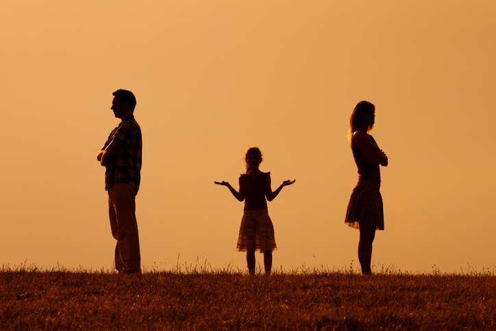 Confused daughter standing in the middle of her angry parents